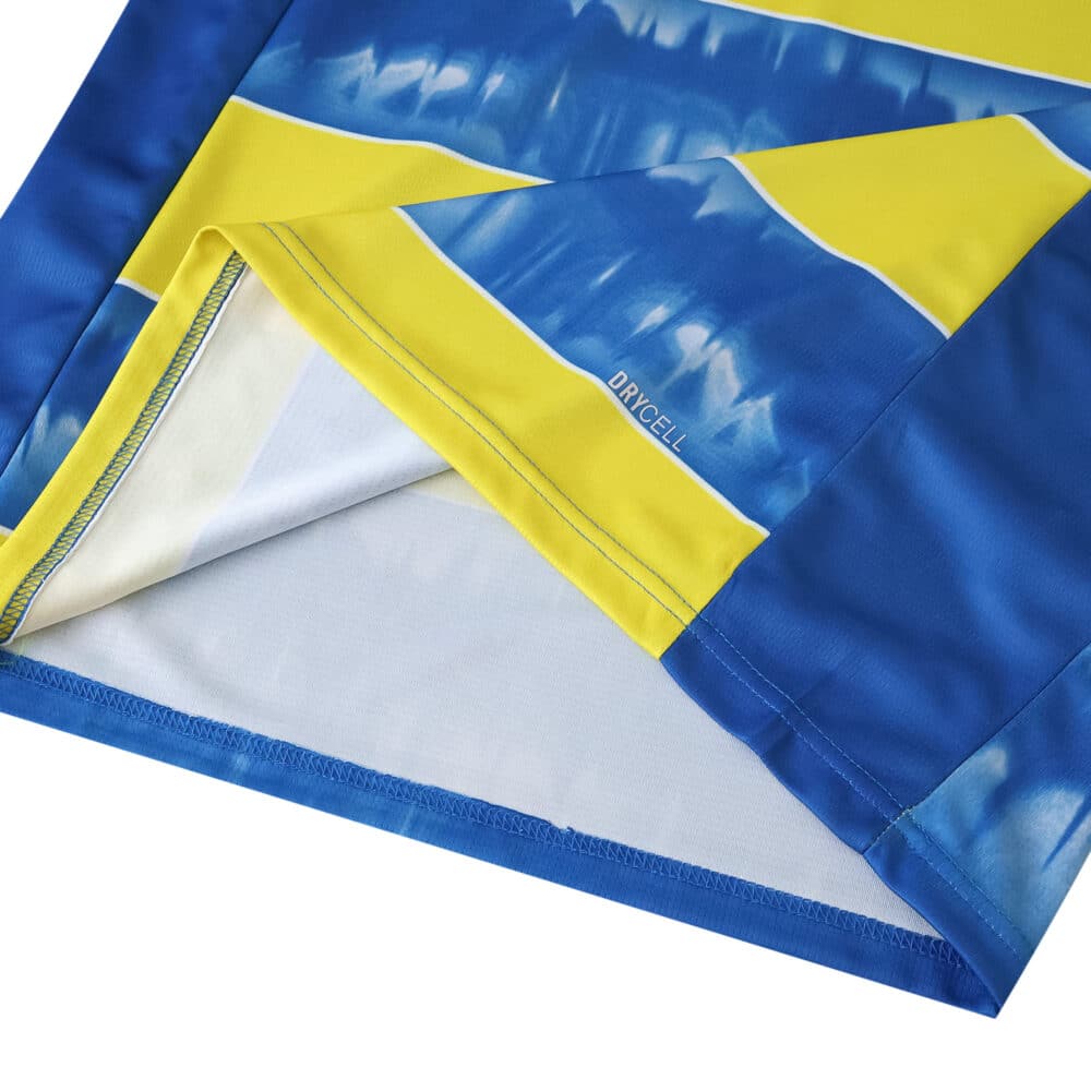 Close-up of Parma Away 2025/26 fan jersey fabric, showing blue and yellow design with DRYCELL detail.