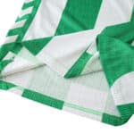 Close-up of Real Betis 2025/26 home player jersey fabric showing green and white stripes and stitching.