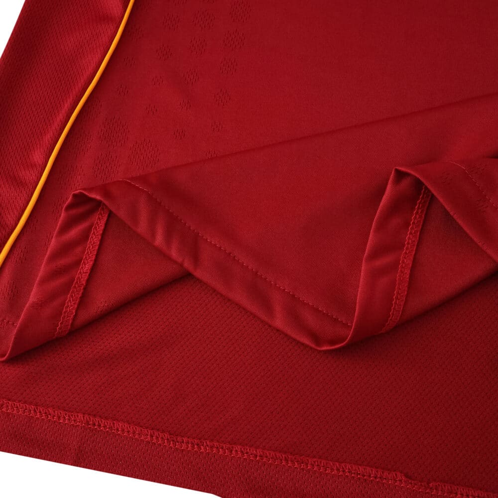 Close-up of the Roma 2025/26 Home Player Version jersey fabric in deep red with gold trim detail.