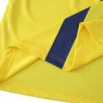 Close-up of Villarreal 2025/26 home fan jersey hem, featuring yellow fabric and a blue diagonal detail.