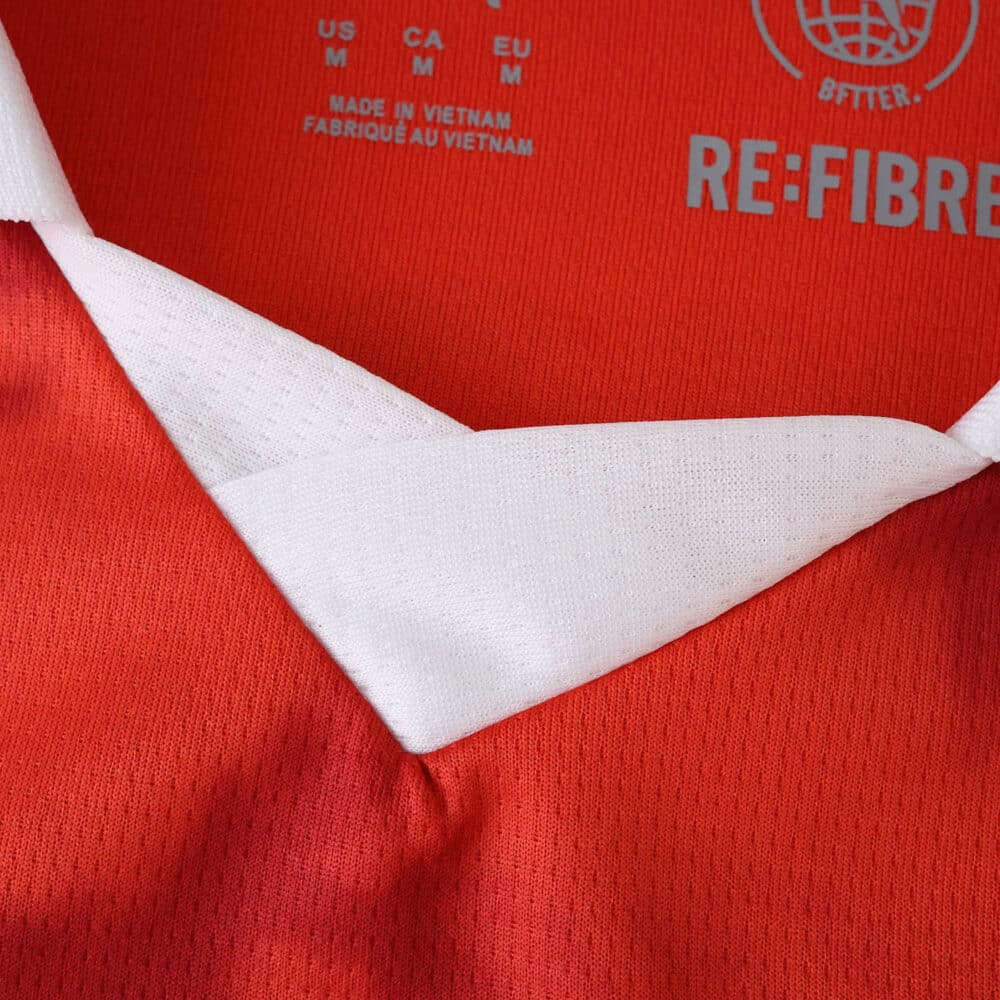 Close-up of the Braga Home 2025/26 fan jersey collar, showing red fabric with a white V-neck design.