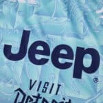 Close-up of the 2025/26 Juventus Away Fan Version jersey showing sponsor logos and abstract blue pattern.