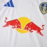 Leeds United 2025/26 home fan jersey showing Red Bull sponsor logo, club crest, and Adidas branding.