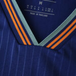 Close-up of the Newcastle United 2025/26 third fan jersey collar in blue with orange and teal stripes.