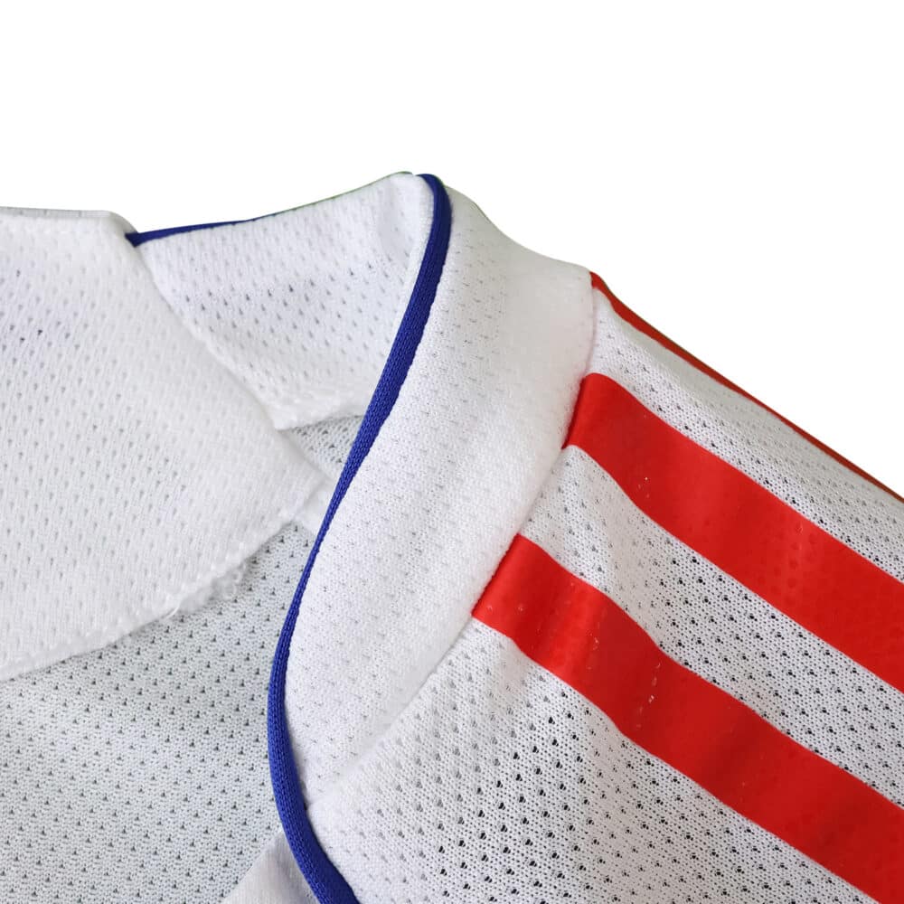Close-up of Olympique Lyonnais 2025/26 home player version jersey collar with red stripes and blue trim.