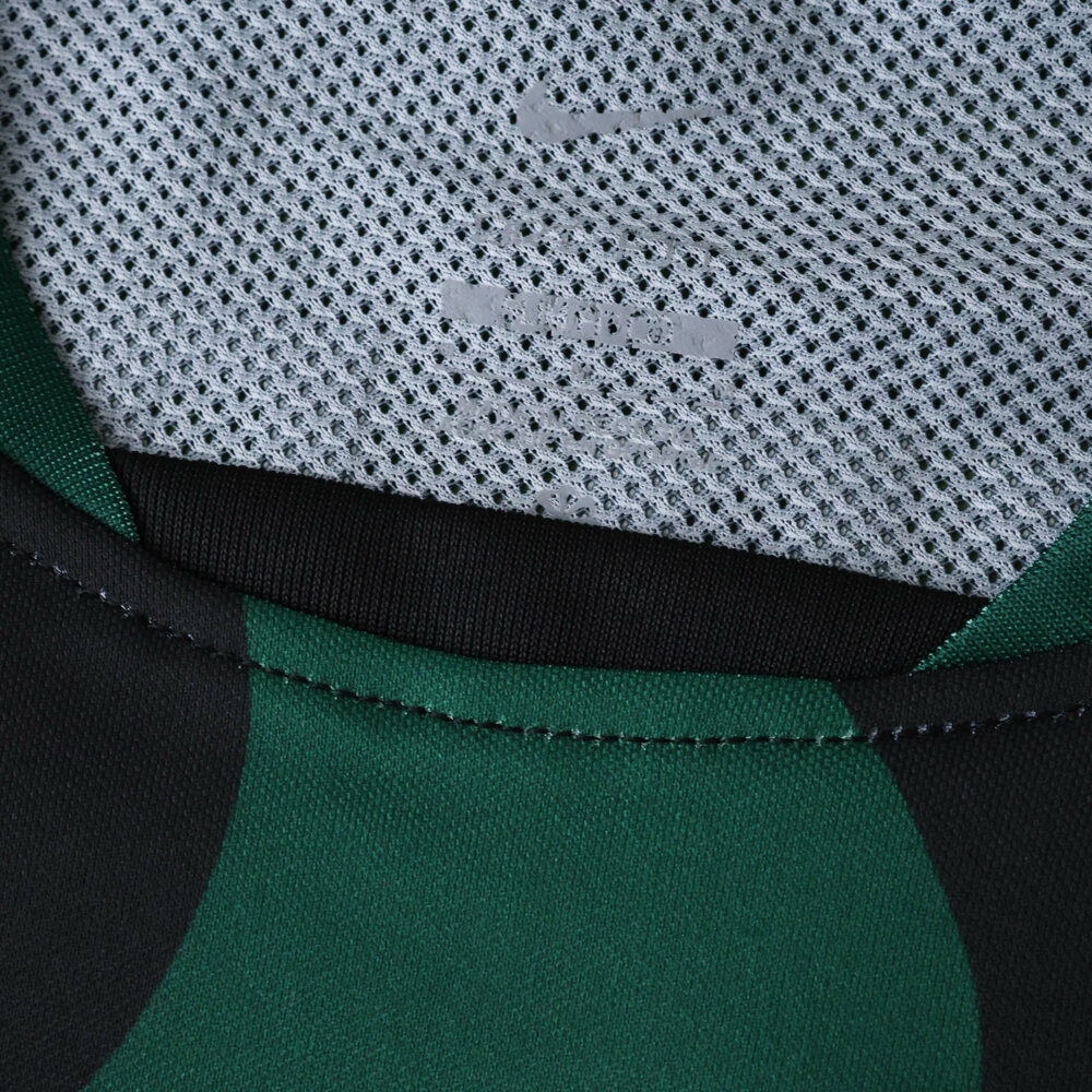 Close-up of Sporting CP Third 2025/26 Fan Version jersey collar with Nike logo on mesh fabric.