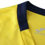 Close-up of the Villarreal 2025/26 home fan jersey collar, showing yellow fabric with a dark blue trim.