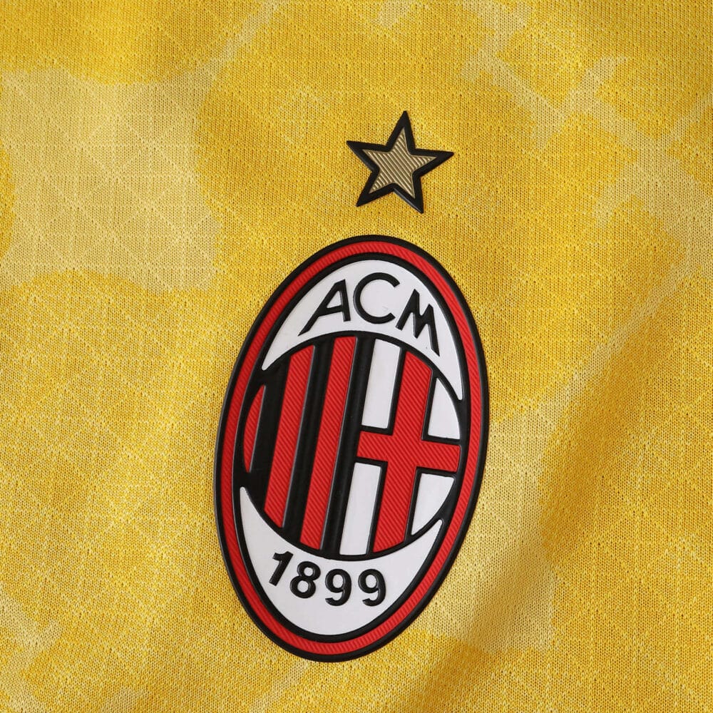 AC Milan 2025/26 Third Player Version jersey detail with club crest and star on yellow fabric.