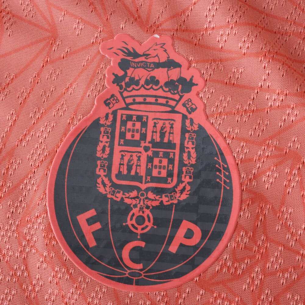 Close-up of the FC Porto crest on the 2025/26 away player version jersey in red.