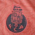Close-up of the FC Porto crest on the 2025/26 away player version jersey in red.