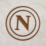 Brown Napoli "N" crest on white fabric for the 2025/26 Away Fan Version jersey.