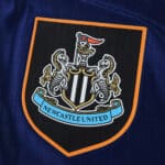 Newcastle United crest on the 2025/26 Third Player Version jersey, close-up view.