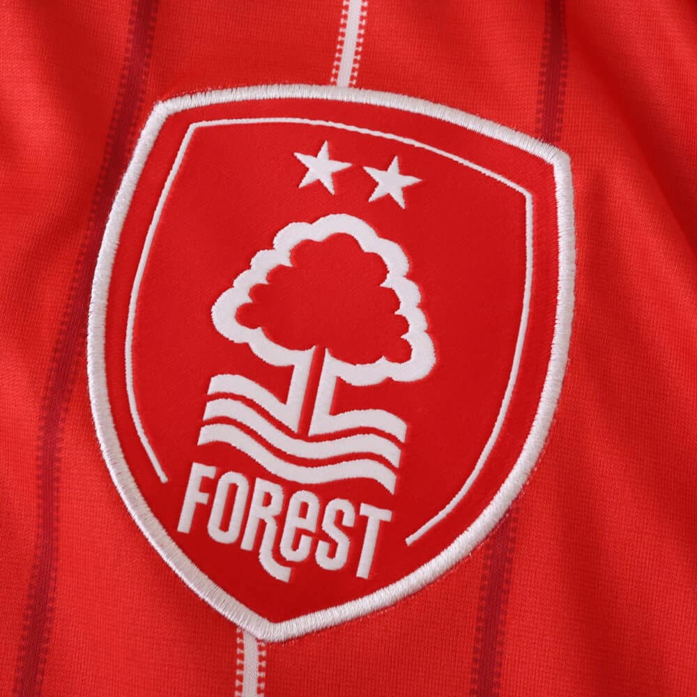 Close-up of Nottingham Forest 2025/26 home fan jersey badge with two stars and white tree emblem.
