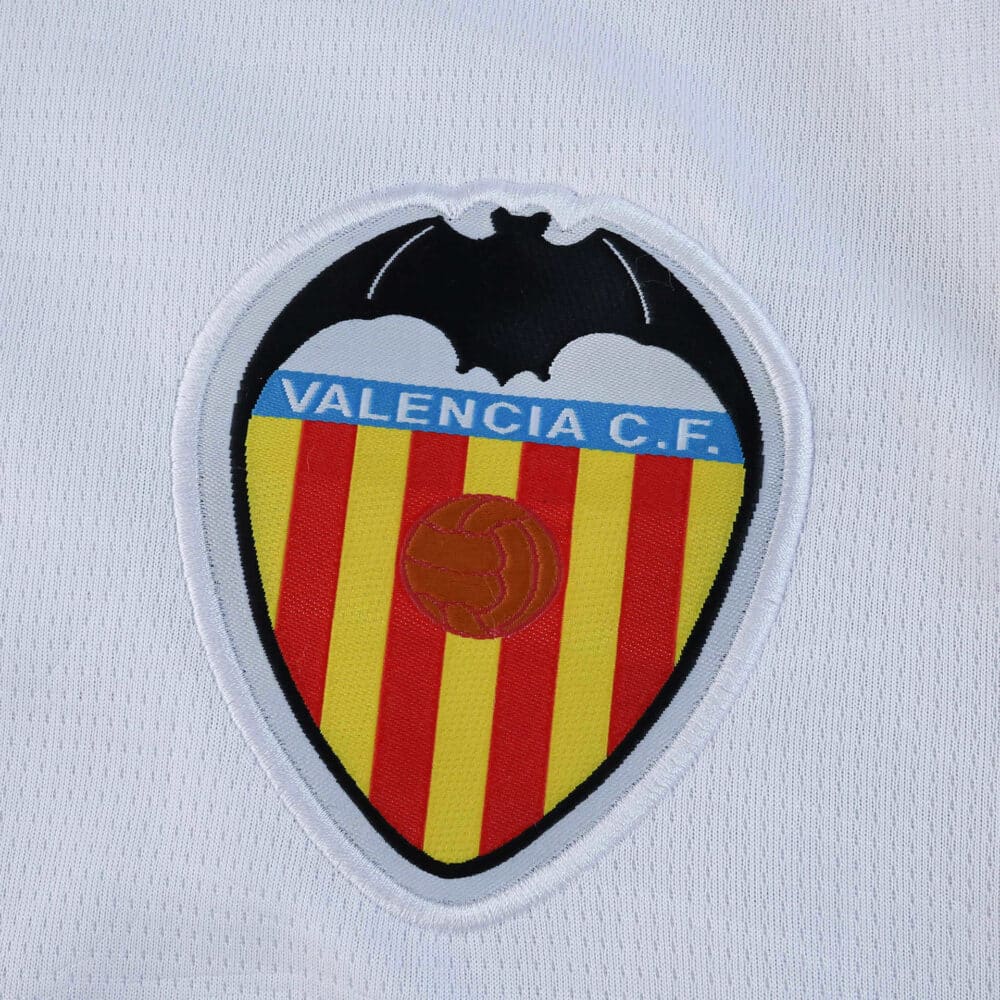 Valencia C.F. 2025/26 fan jersey crest featuring the club's bat logo on white fabric.