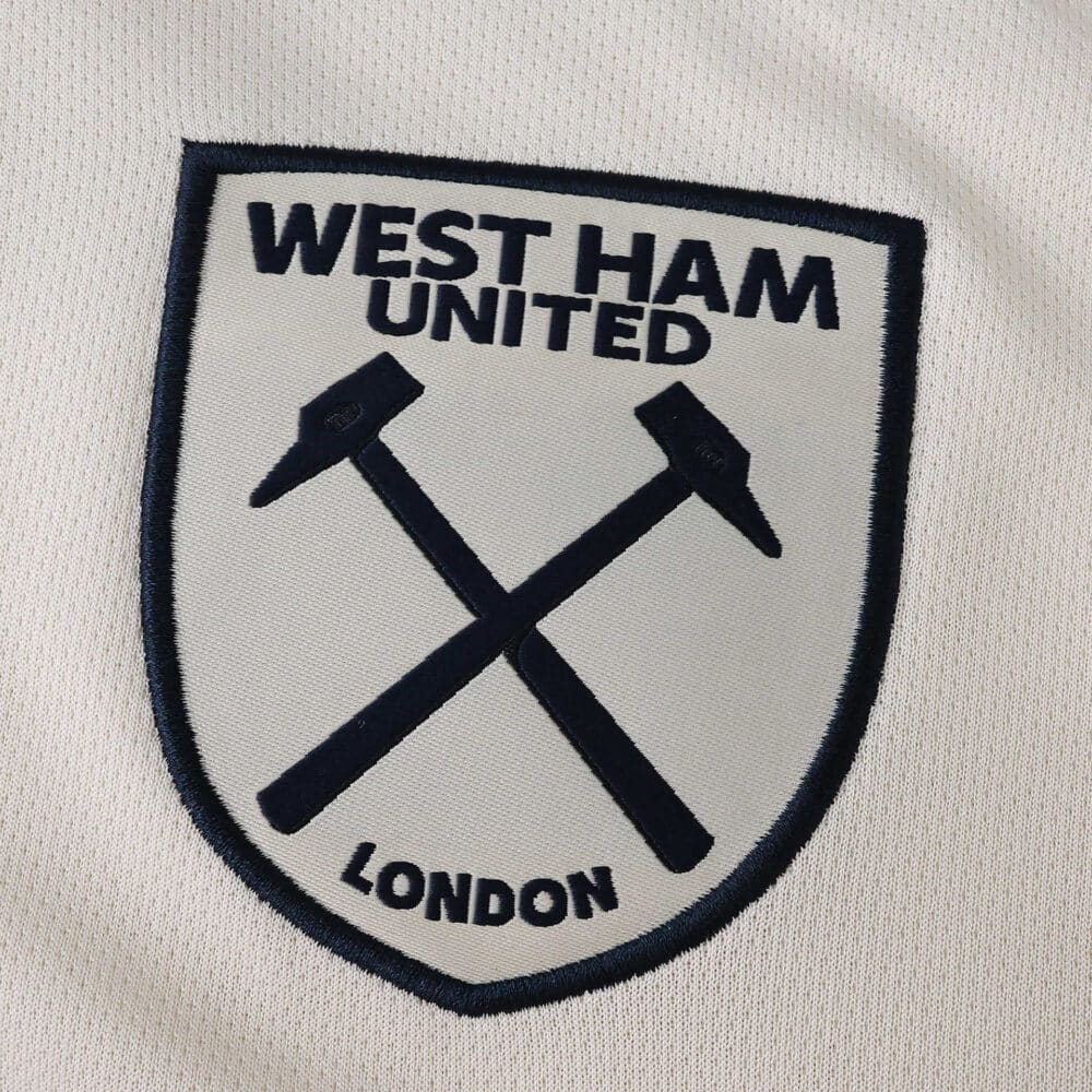 West Ham United 2025/26 away fan version badge with crossed hammers on white fabric.