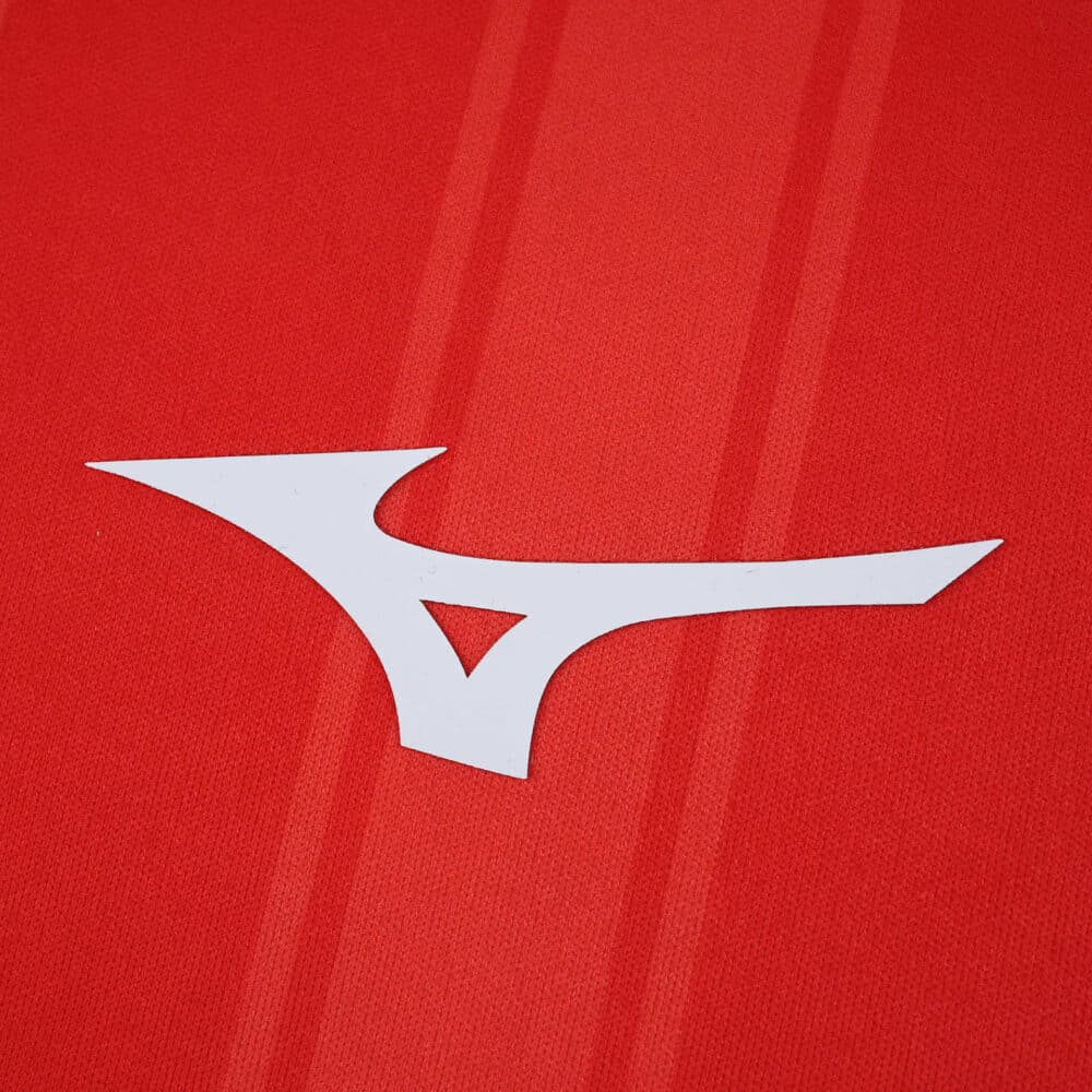 Close-up of the Mizuno logo on the red AS Monaco 2025/26 Player Version home jersey fabric.