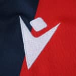 Close-up of the Bologna Home 2025/26 Fan Version jersey featuring the white Macron logo on red and navy fabric.