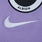Close-up of the Brighton & Hove Albion 2025/26 away fan shirt with Nike logo on purple fabric.