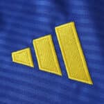 Yellow Adidas logo embroidered on blue Leeds United 2025/26 Away Fan Version jersey fabric.