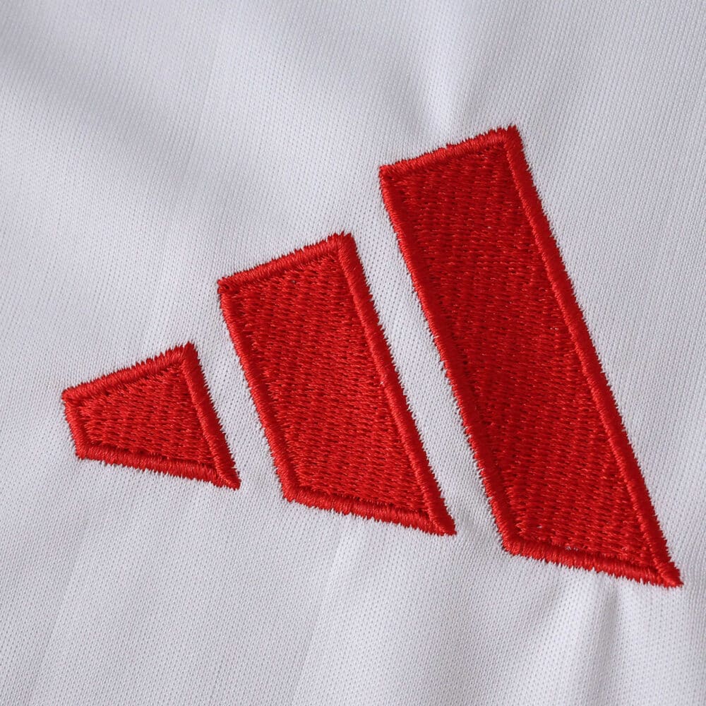 Close-up of the red Adidas logo embroidered on the Sevilla FC 2025/26 Home Fan Version jersey.
