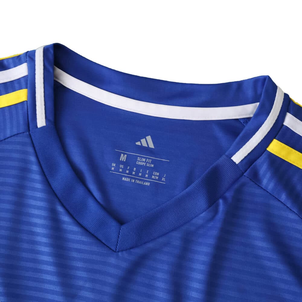 Close-up of Leeds United Away 2025/26 Fan Version jersey, featuring blue fabric with white and yellow shoulder stripes.