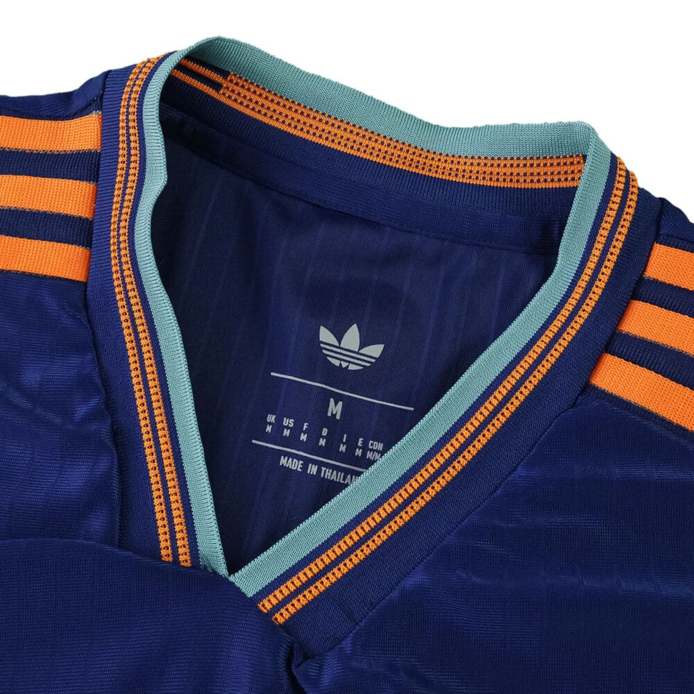 Close-up of Newcastle United Third 2025/26 Player Version collar with teal trim and orange stripes.