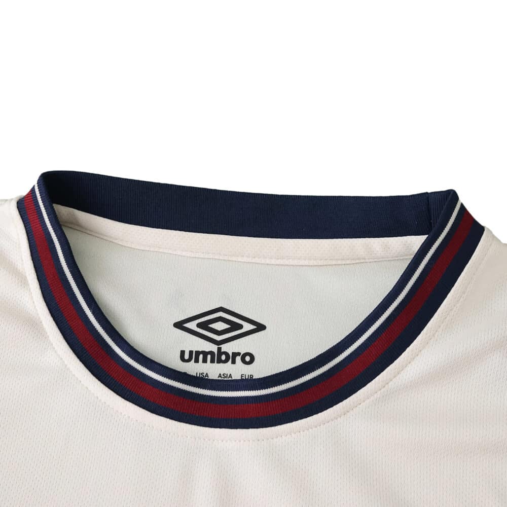 Close-up of West Ham United 2025/26 away fan jersey collar in white with navy and claret trim, Umbro logo visible.