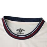 Close-up of West Ham United 2025/26 away fan jersey collar in white with navy and claret trim, Umbro logo visible.