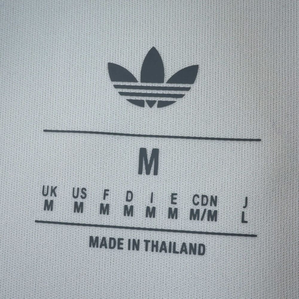 Adidas logo and size label for Aston Villa Third 2025/26 Fan Version jersey, showing "M" made in Thailand.