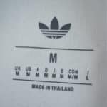 Adidas logo and size label for Aston Villa Third 2025/26 Fan Version jersey, showing "M" made in Thailand.