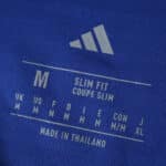 Adidas logo and size label on Leeds United Away 2025/26 Fan Version shirt, showing medium size and slim fit.