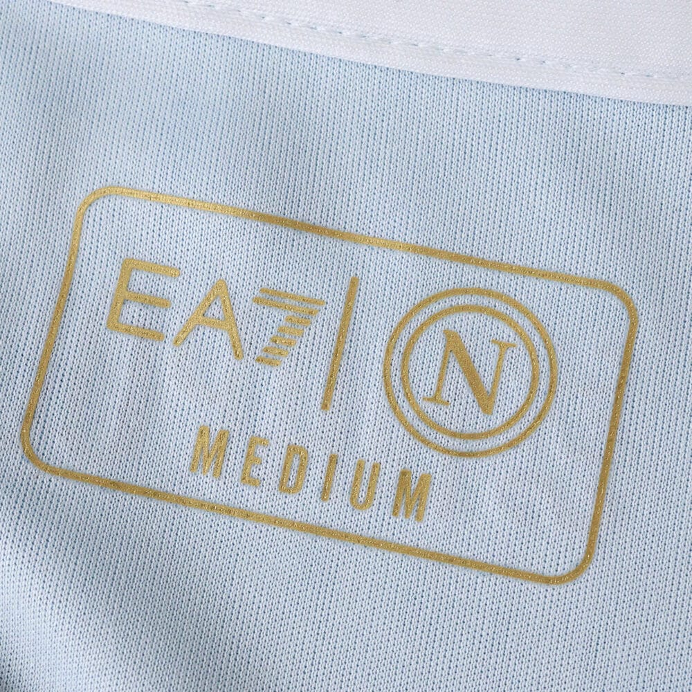Close-up of the Napoli 2025/26 home fan jersey label showing EA7 logo, N crest, and "Medium" size.