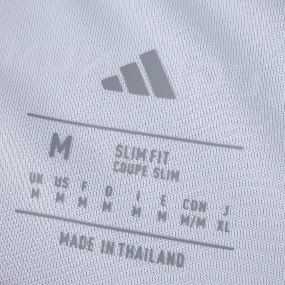 Close-up of Olympique Lyonnais 2025/26 Home Fan Version shirt size tag, showing slim fit and made in Thailand.