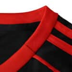 Close-up of Sevilla FC Third 2025/26 Fan Version jersey showing red collar and black fabric with red stripes.