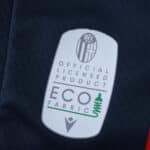Close-up of Bologna FC 2025/26 fan version jersey featuring official licensed product and eco fabric label.