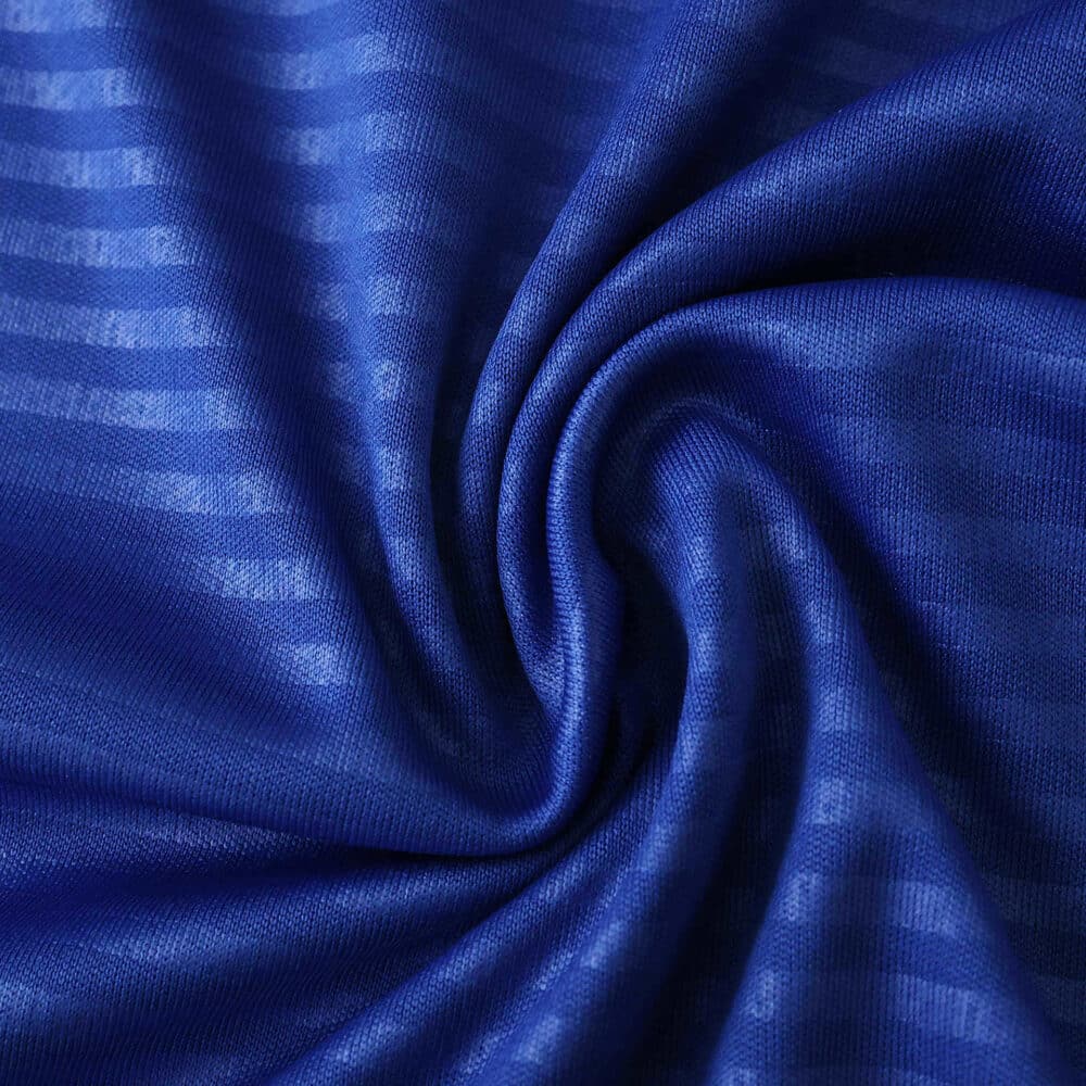 Close-up of blue Leeds United Away 2025/26 Fan Version fabric showing texture and subtle stripe pattern.