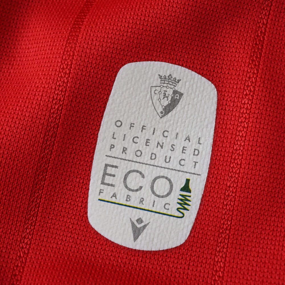 Close-up of eco fabric label on the 2025/26 Osasuna Home Fan Version jersey.
