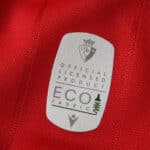 Close-up of eco fabric label on the 2025/26 Osasuna Home Fan Version jersey.