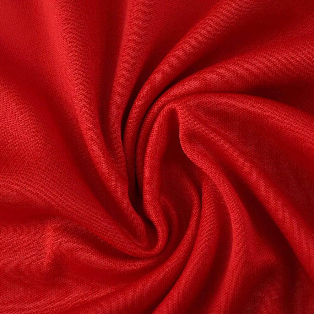 Close-up of red fabric used in the Sevilla FC Away 2025/26 Fan Version jersey, showing texture and color.