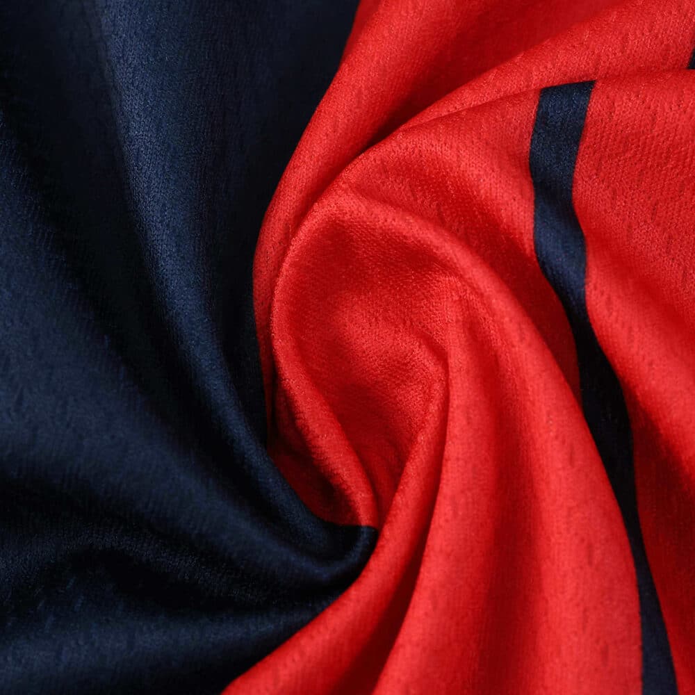 Close-up of Bologna Home 2025/26 Fan Version jersey fabric featuring red and navy blue colors.
