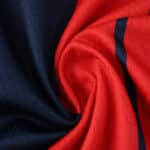 Close-up of Bologna Home 2025/26 Fan Version jersey fabric featuring red and navy blue colors.