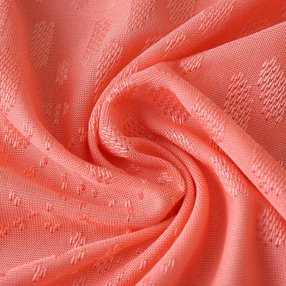 Close-up of FC Porto Away 2025/26 Player Version fabric in coral pink, showing textured details and weave.