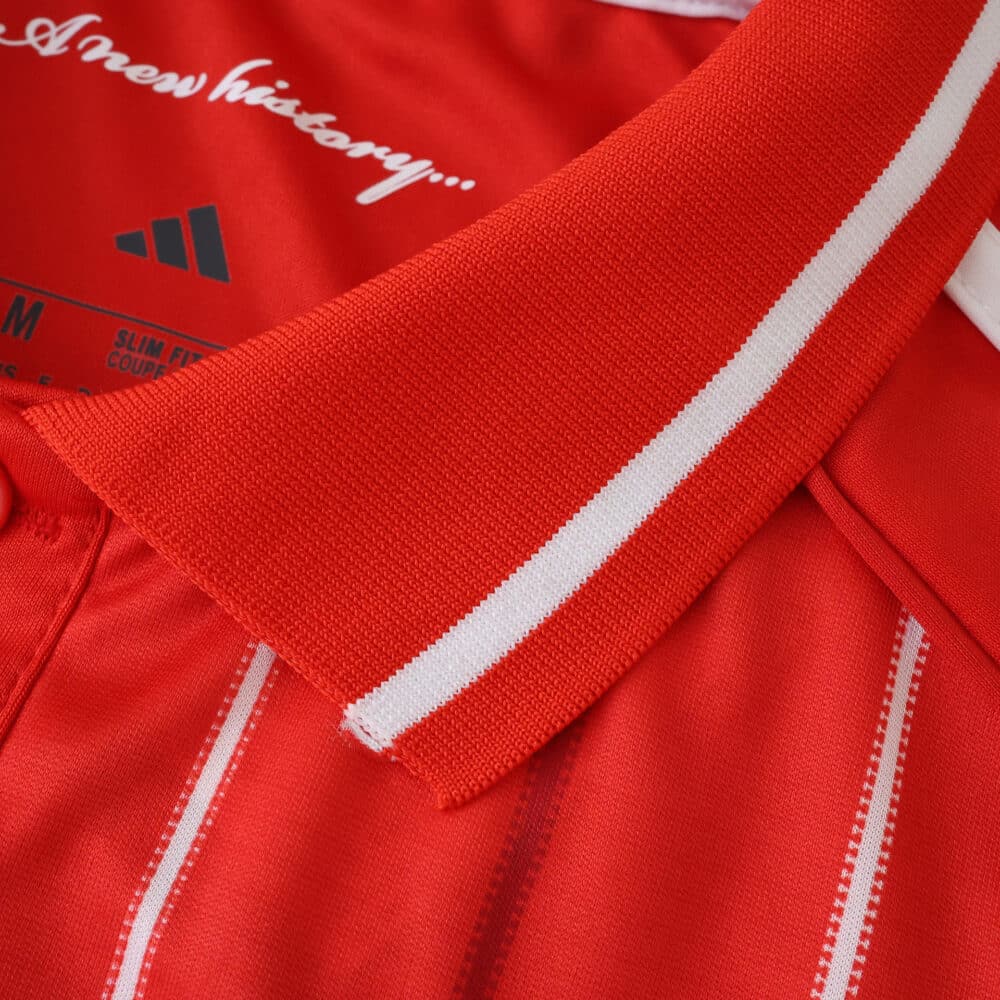 Close-up of Nottingham Forest 2025/26 home fan jersey collar with white stripe detail on red fabric.