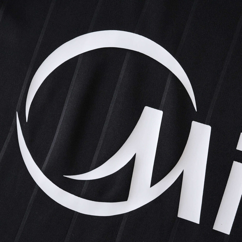 Close-up of the Sevilla FC 2025/26 third fan version jersey featuring a white sponsor logo on black fabric.