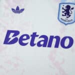 Aston Villa 2025/26 third fan jersey with club crest, Betano sponsor, and Adidas logo on white fabric.