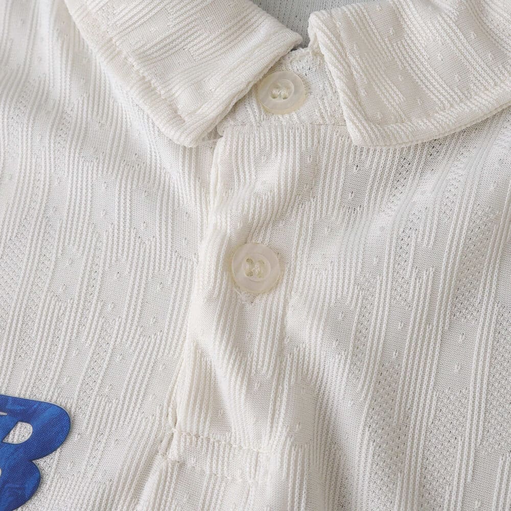 Close-up of FC Porto 2025/26 Third Player Version jersey collar and buttons in textured white fabric.