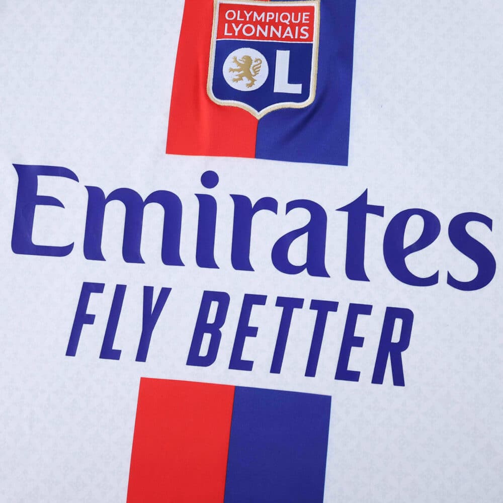 Close-up of Olympique Lyonnais 2025/26 home fan jersey with club badge and Emirates Fly Better sponsor.