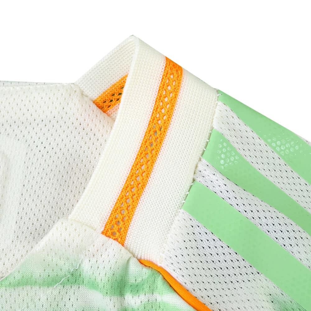 Close-up of Celtic Third 2025/26 Player Version jersey collar with orange and green accents.
