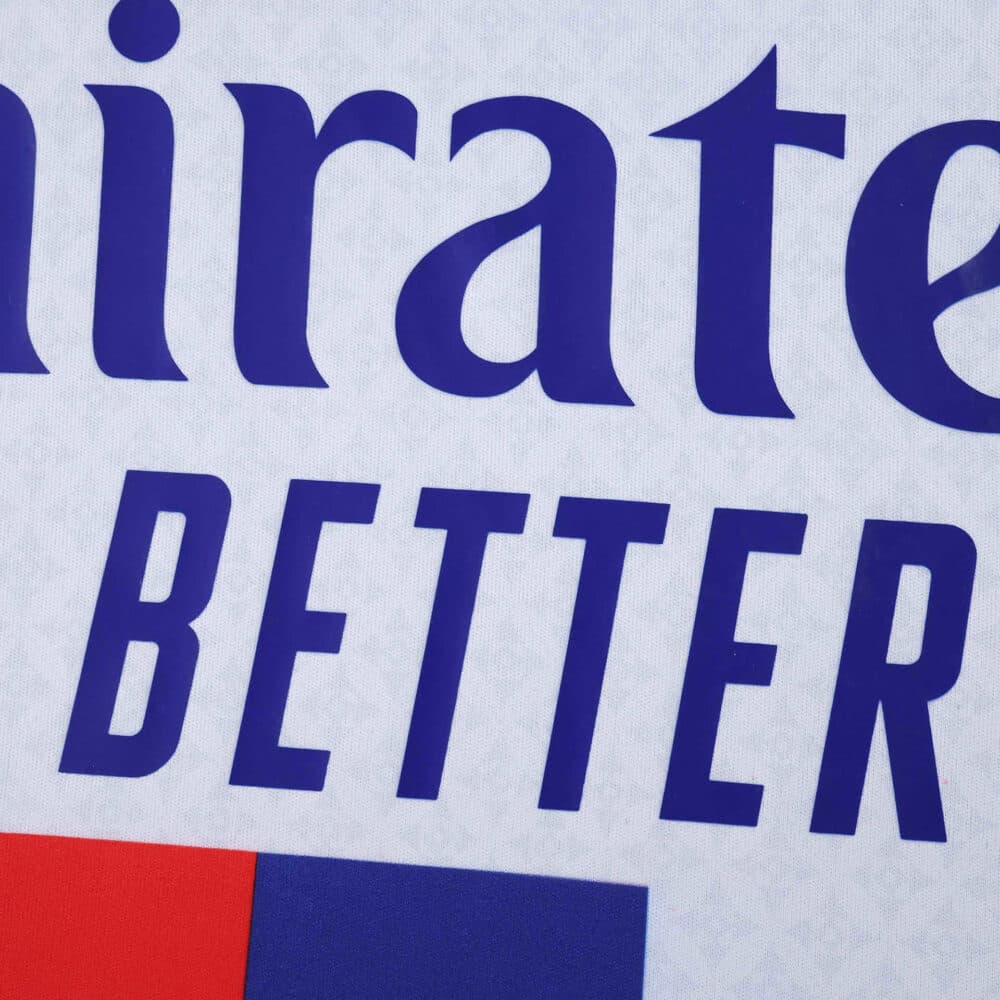 Close-up of Olympique Lyonnais 2025/26 Home Fan Jersey showing sponsor logo text in blue.