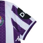 Real Valladolid 2025/26 home fan jersey sleeve with club crest, purple stripes, and sponsor patch.